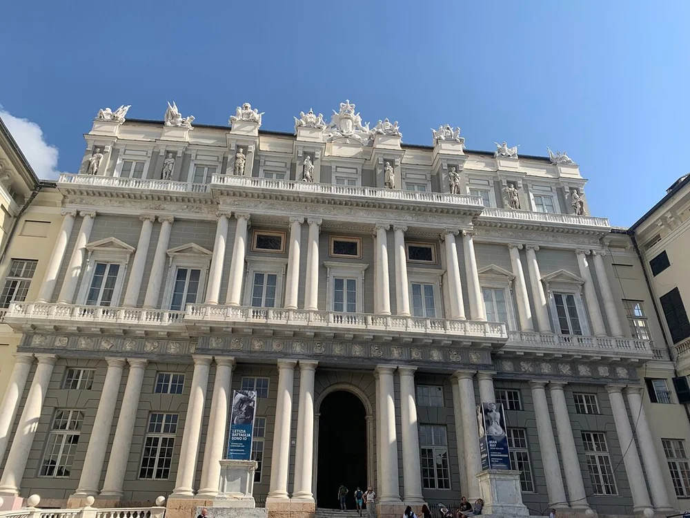 Die reich verzierte weiße Fassade eines prächtigen Palazzo in Genua unter blauem Himmel